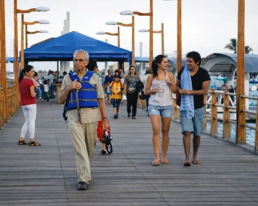 People walk along a wooden pier in Puerto Ayora on Santa Cruz Island, reflecting the daily movement of residents and visitors in Galápagos.