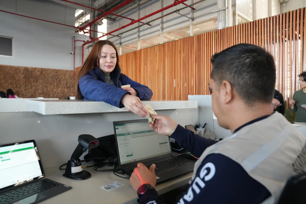 A visitor pays an entry fee at a control counter before traveling to Galápagos.